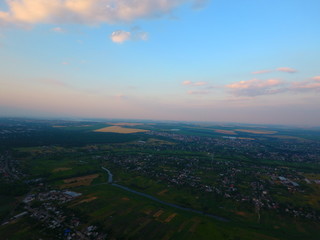 Fototapeta premium Aerial view of beautiful village, houses, roads. Sky, clouds.