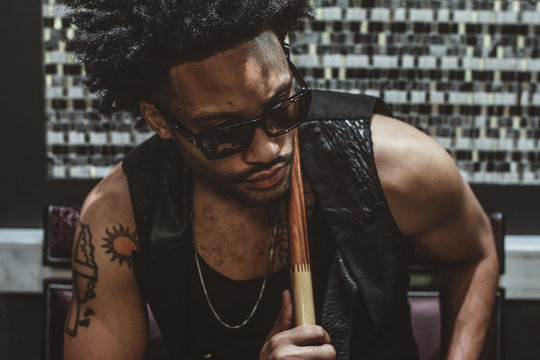 red ball, sexy Man with tattoos and jewelry with cue IN THE HANDS