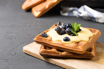 Crispy wafers with cream and berries, horizontal, black background, close-up, selective focus