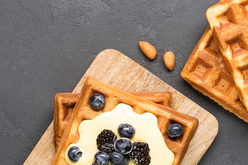 Crispy wafers with cream and berries, horizontal, top view, black background, close-up, soft focus