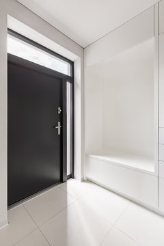 White entryway with black door