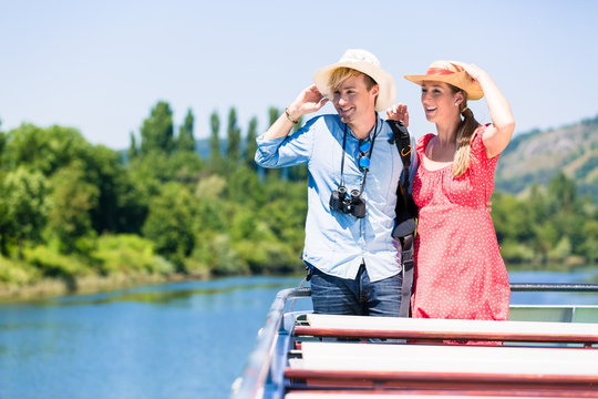 Happy Couple On River Cruise Wearing Sun Hats In Summer Enjoying Their Time