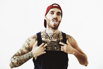 tattooed rap singer posing in studio on a white background
