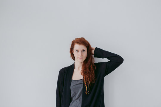 Serious portrait of red head woman on simple white background