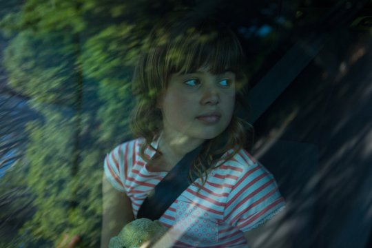 Teenage girl with teddy bear sitting in the back seat of car - Powered by Adobe