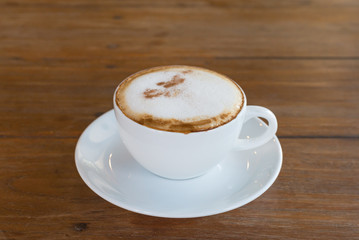 cappuccino in white coffee cup on wood table, coffee time.