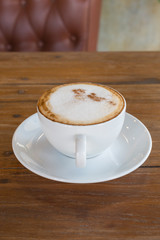 cappuccino in white coffee cup on wood table, coffee time.
