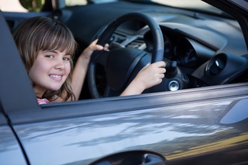 Fototapeta na wymiar Happy teenage girl driving a car