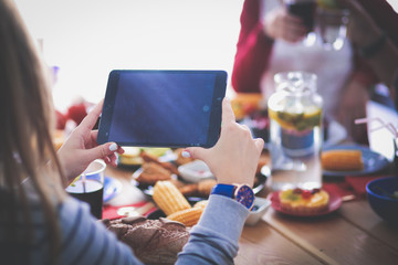 Top view of group of people having dinner together while sitting at wooden table. Food on the table. People eat fast food.