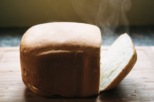 Fresh loaf of white bread with steam coming out of the inside