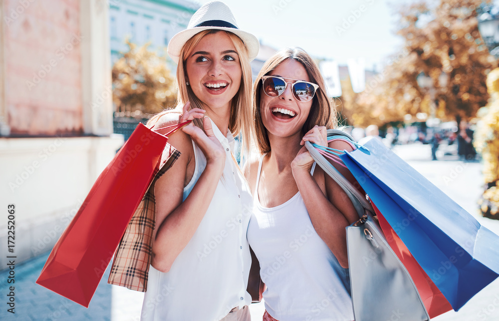 Wall mural shopping time. young women shopping together. consumerism, shopping, lifestyle