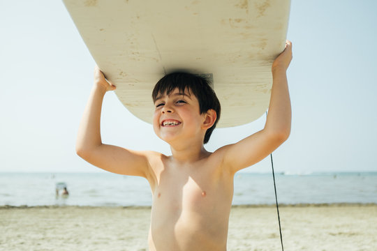 Boy Carrying Wake Board Over His Head