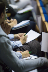 Group of People Making Notes at Conference. Sitting in One Line. Blurred Image.