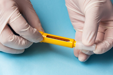 A man in medical gloves holds a syringe for subcutaneous injection of hormonal drugs in the IVF protocol in vitro fertilization Pregnancy, help to his wife.