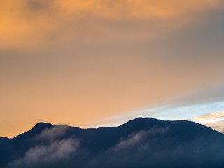 Obraz premium Colorful Sky and Clouds drifting over the forest mountain in evening time
