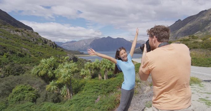 Couple taking pictures in nature landscape on travel by lake Hawea nature landscape. Near Wanaka, Otago Region. Couple tourists on travel adventure having fun.