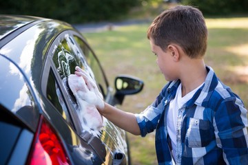 Teenage boy washing a car - Powered by Adobe