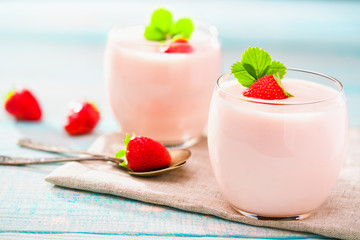 Homemade strawberry yogurt on a turquoise wooden background