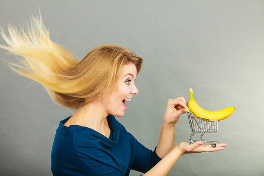 Woman holding shopping cart with banana inside