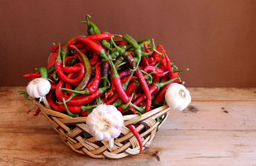 cesto sardo con peperoncini e teste d'aglio su sfondo di legno