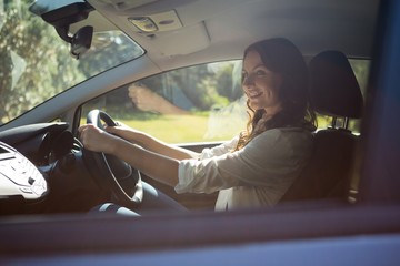Fototapeta na wymiar Smiling woman driving a car