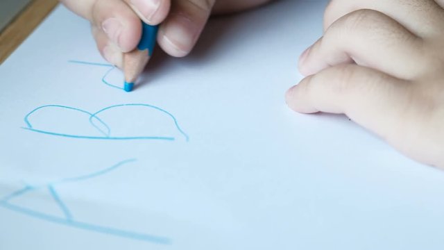 Child's hand writing a b c alphabet.