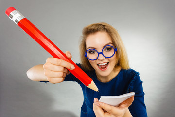 Crazy woman holds big pencil in hand