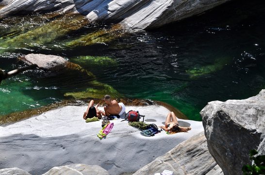 Junge Menschen in Badekleider beim Sonnenbad in Ponte Brolla, Fluss Maggia, Maggiatal - Tessin, Schweiz