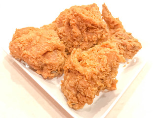 crispy kentucky fried chicken on a white plate and table.