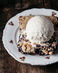 Homemade fresh blueberry pie with ice-cream on rustic background