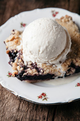 Homemade fresh blueberry pie with ice-cream on rustic background