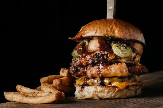 Juicy Burger With Onion Rings And Pickled Jalapenos