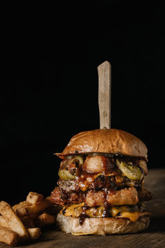 Double Stacked Burger With French Fries On Dark Background