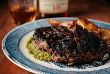 Grilled Ribeye Steak with potatoes on a vintage plate