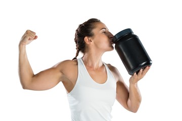 Female athlete flexing muscles while kissing supplement jar - Powered by Adobe