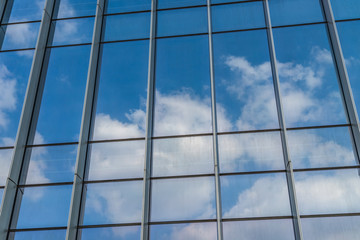 Clouds reflected in windows of modern office building.