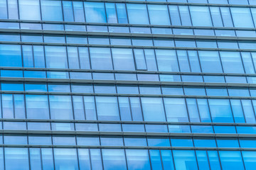 Fototapeta na wymiar Clouds Reflected in Windows of Modern Office Building..