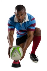 Full length portrait of male rugby player keeping ball on tee