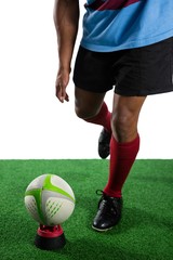 Fototapeta premium Low section of male athlete kicking rugby ball