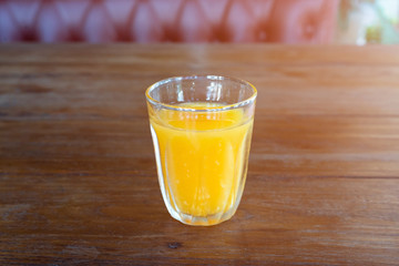 orange juice glass on wood table