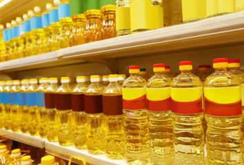 Bottles with cooking oil on shelves in supermarket