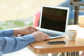 Young man working with laptop at table