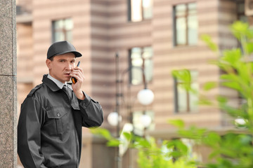 Male security guard with portable radio, outdoors