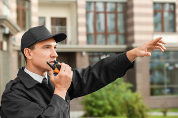 Male security guard with portable radio, outdoors