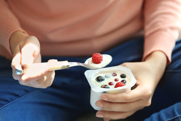 Young woman eating yogurt, closeup