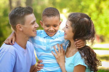 Young family with adopted African American boy outdoors