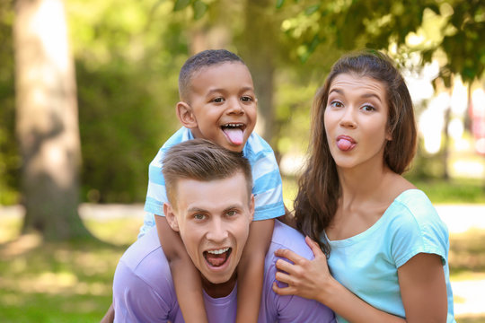 Young family with adopted African American boy having fun outdoors