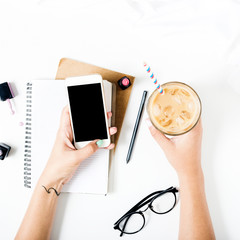 Close up feminine workspace with smartphone in female hands