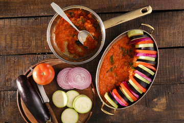 Ingredients for cooking vegetarian dish ratatouille on a wooden table