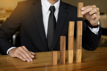 Concept growing value. hand of businessman pick up a wooden block like bar graph growth.